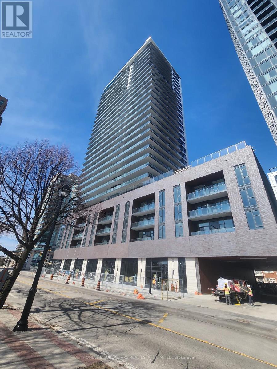 A tall building with a curved facade stands next to a shorter building with a flat facade.