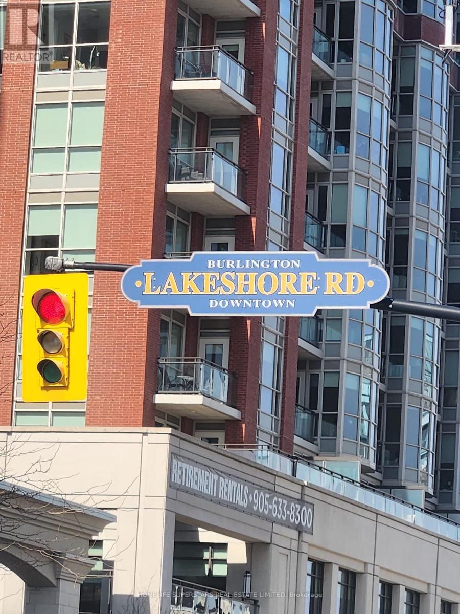 A red and white street sign for Burlington Lakeshore Rd. is in front of a building.