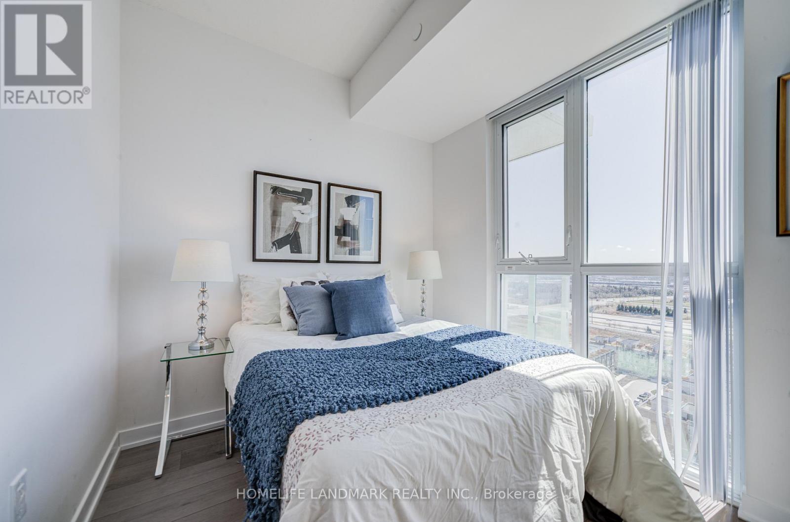 A bedroom with a large bed and a view of the city.