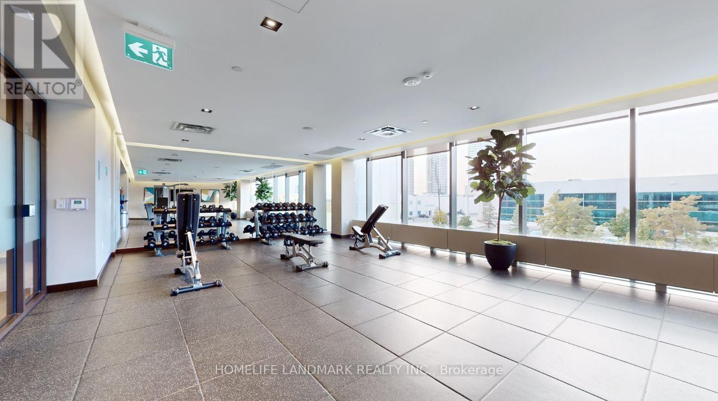 A spacious gym with exercise equipment and a view of the city.