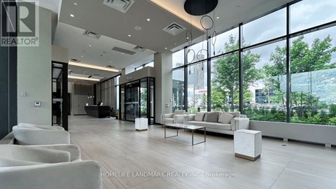 A modern living room with white furniture and large windows.