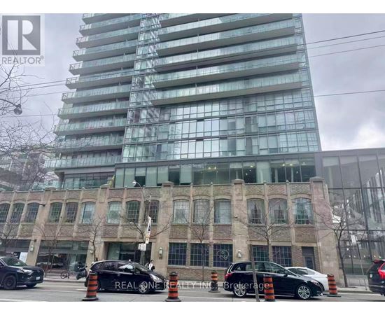 A black car with the text REALTOR on the side is parked in front of a building.