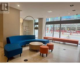 A blue couch and orange ottoman are in a room with a large window.