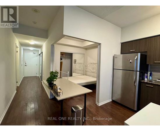 A kitchen with a refrigerator, table and chairs.