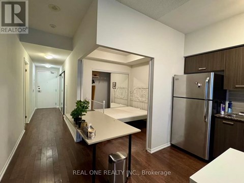 A kitchen with a refrigerator, table and chairs.