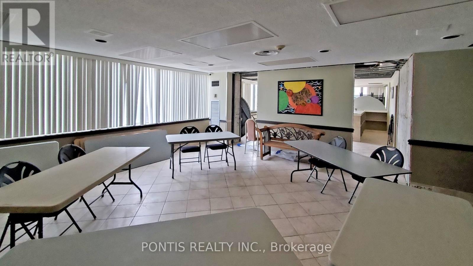 A conference room with a long table and chairs, and a painting on the wall.