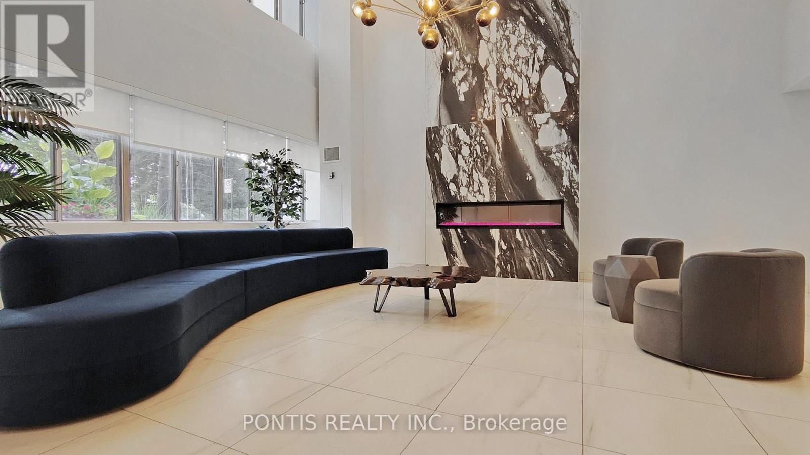 A living room with a blue couch and a large abstract painting on the wall.