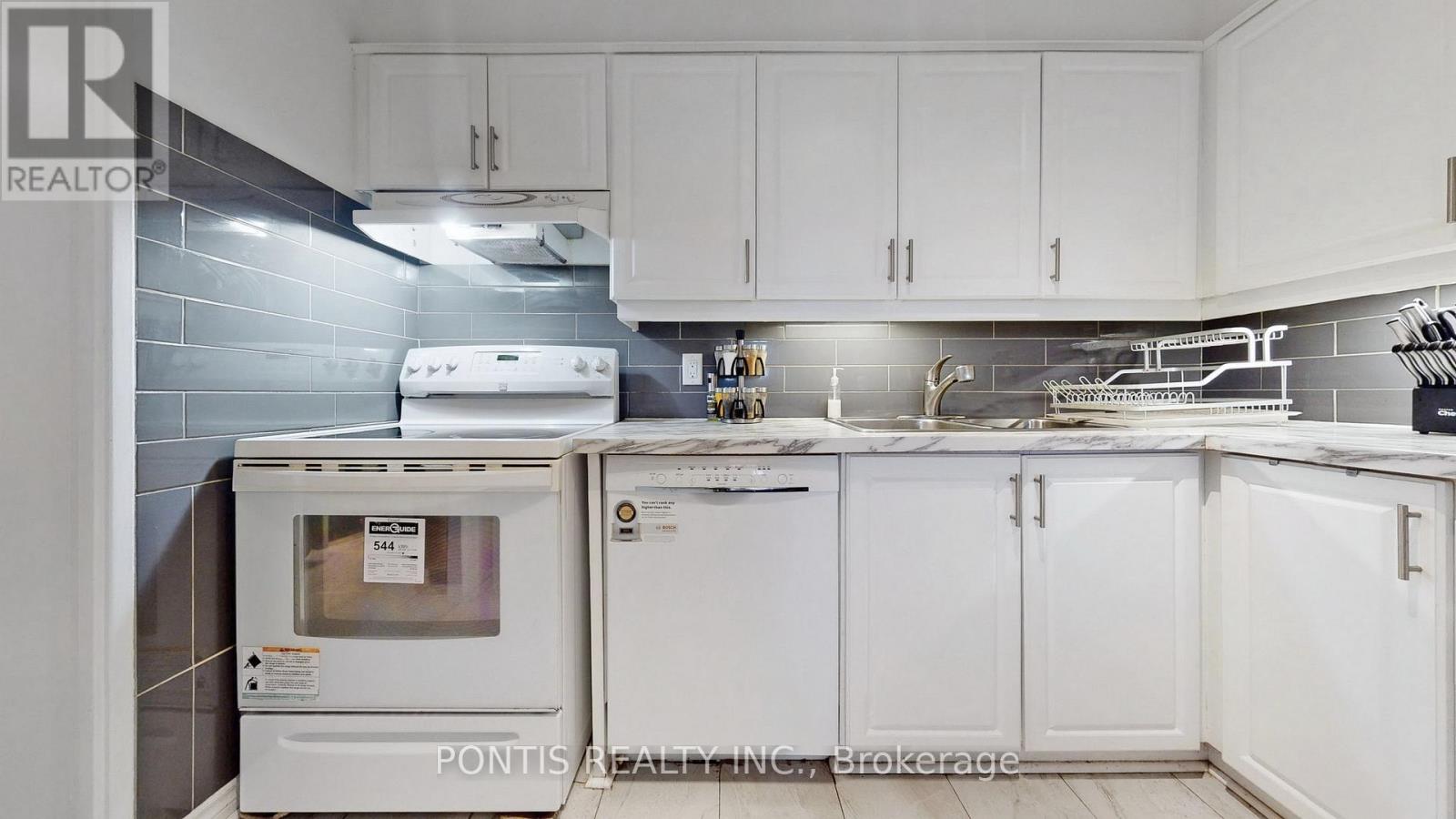 A kitchen with white cabinets and a white oven.