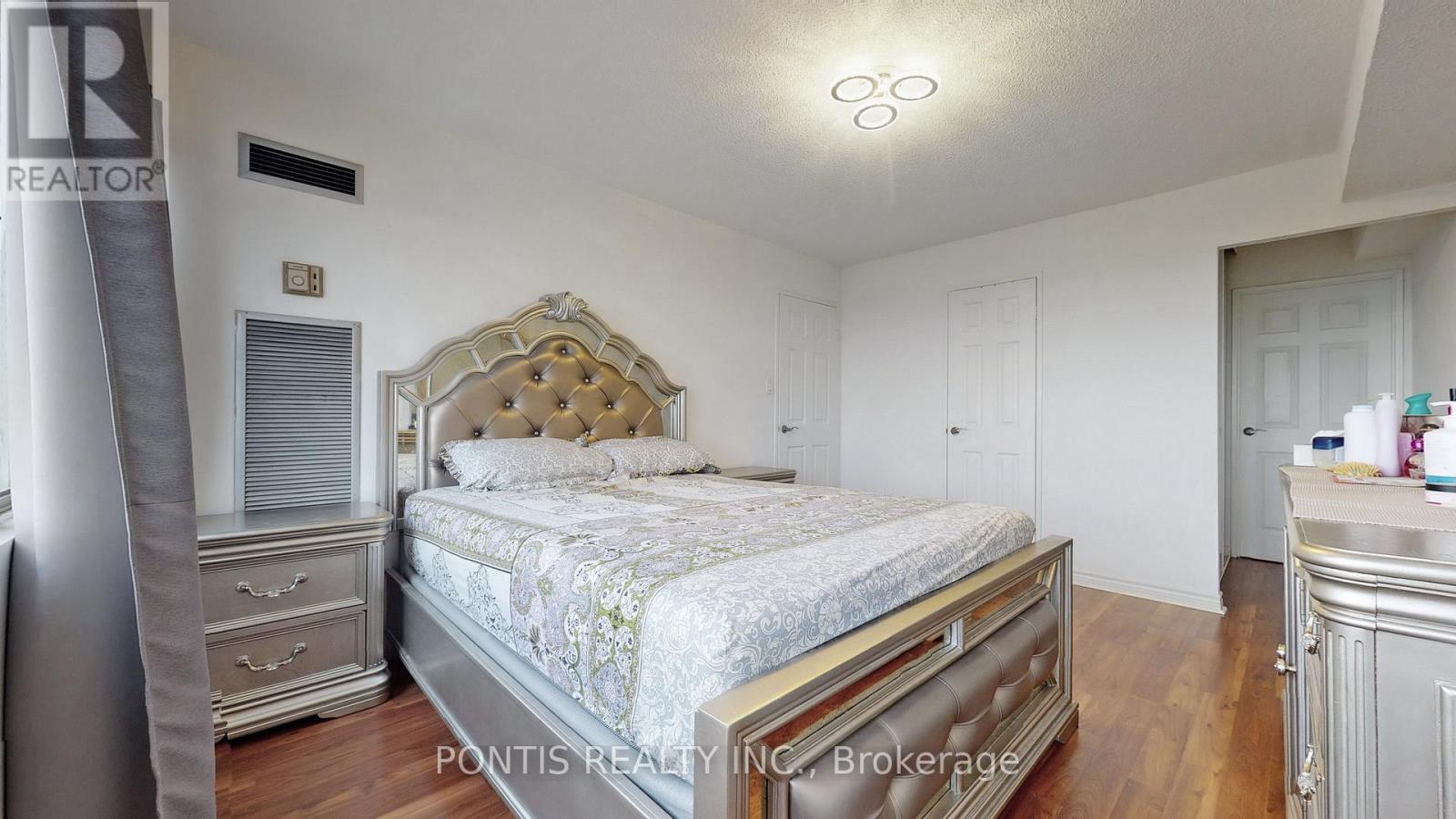 A bedroom with a large bed and a dresser.