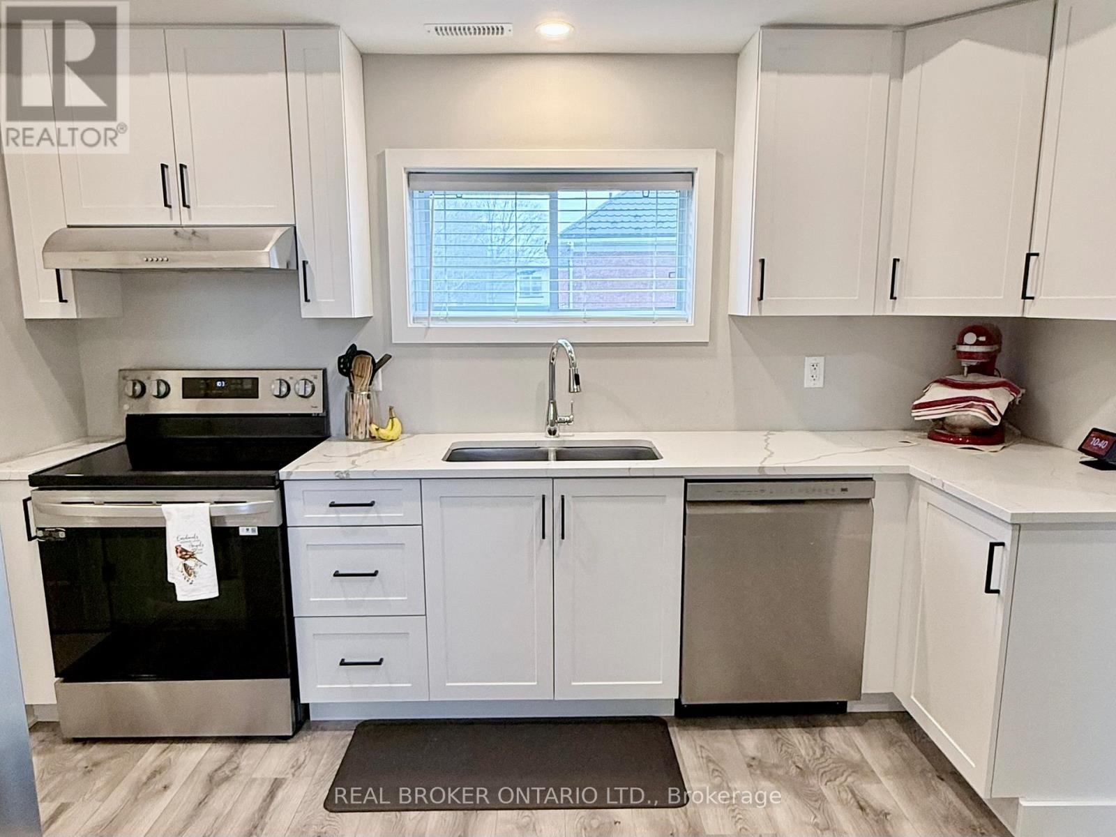 A kitchen with white cabinets and a black stove top oven.