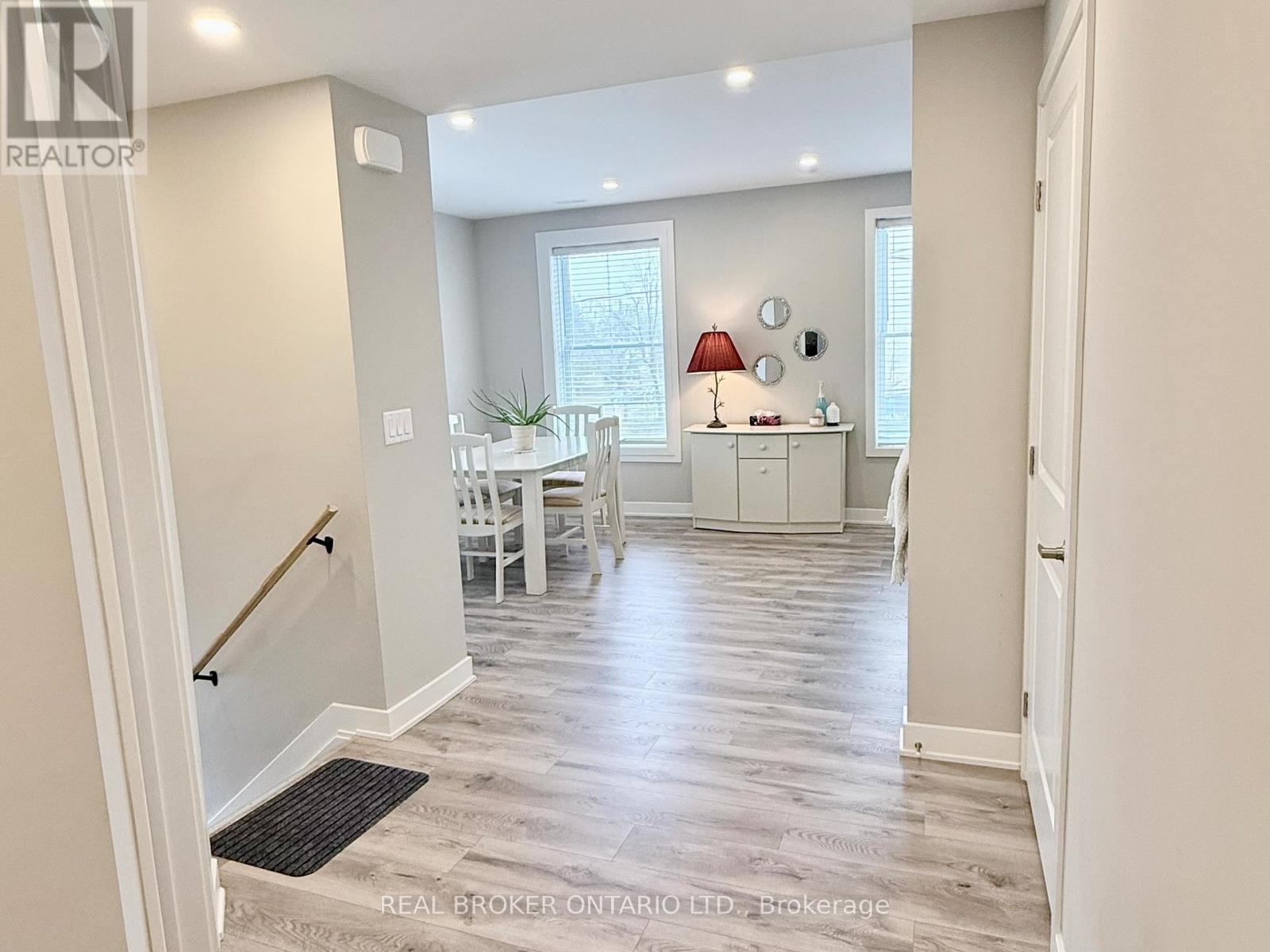 A well-lit, spacious living room with a dining area and a staircase.