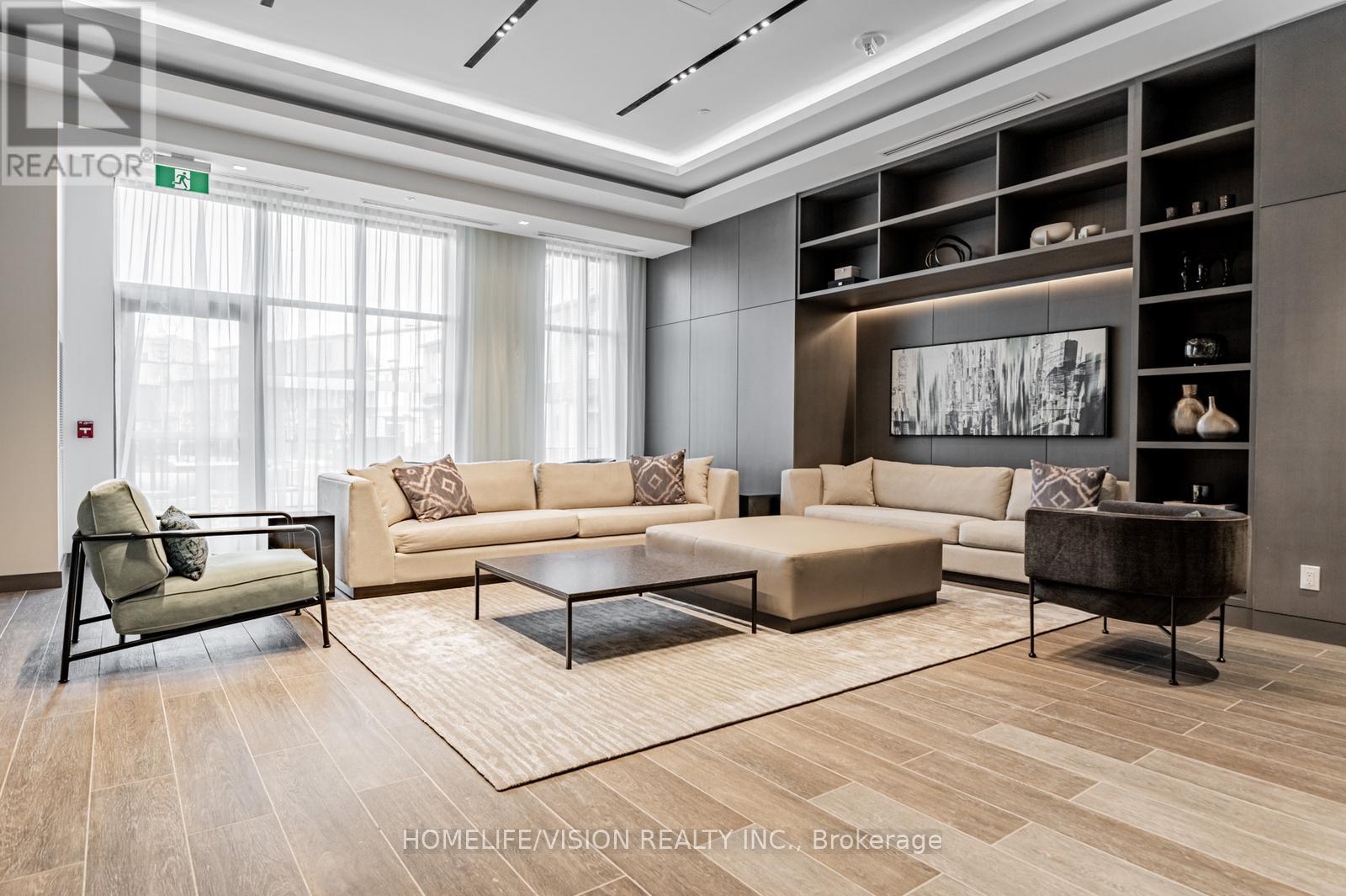A living room with a beige couch, a black chair, and a coffee table.