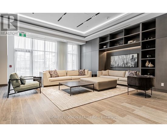 A living room with a beige couch, a black chair, and a coffee table.