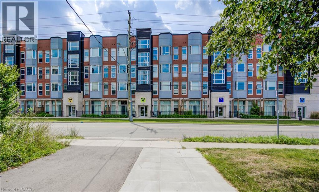 A row of modern apartment buildings with a REALTOR sign in front.