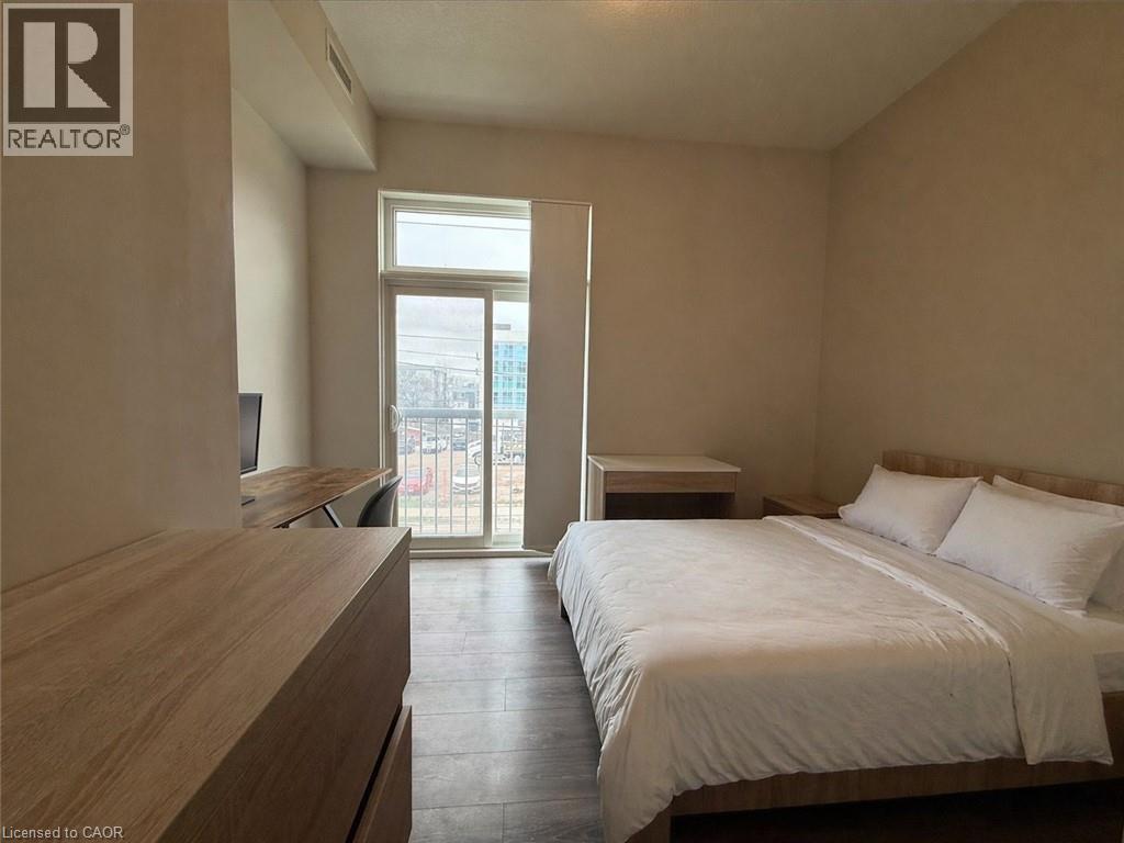 A bedroom with a large bed and a balcony with a view of the city.