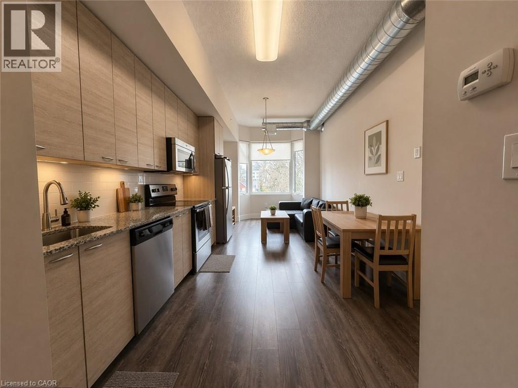 A well-lit kitchen with wooden floors and a dining area with a table and chairs.