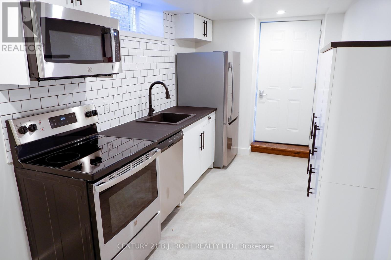 A kitchen with a stove top oven, microwave, and refrigerator.