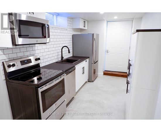 A kitchen with a stove top oven, microwave, and refrigerator.