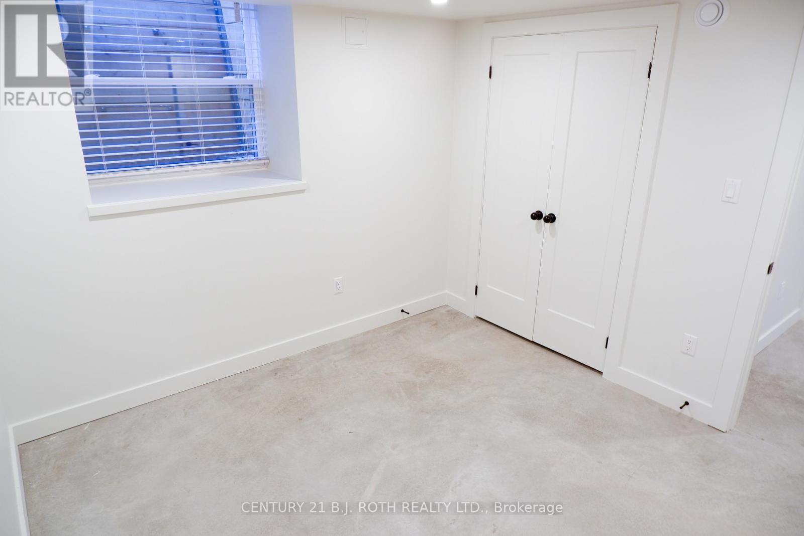 A white door is in a room with a window.
