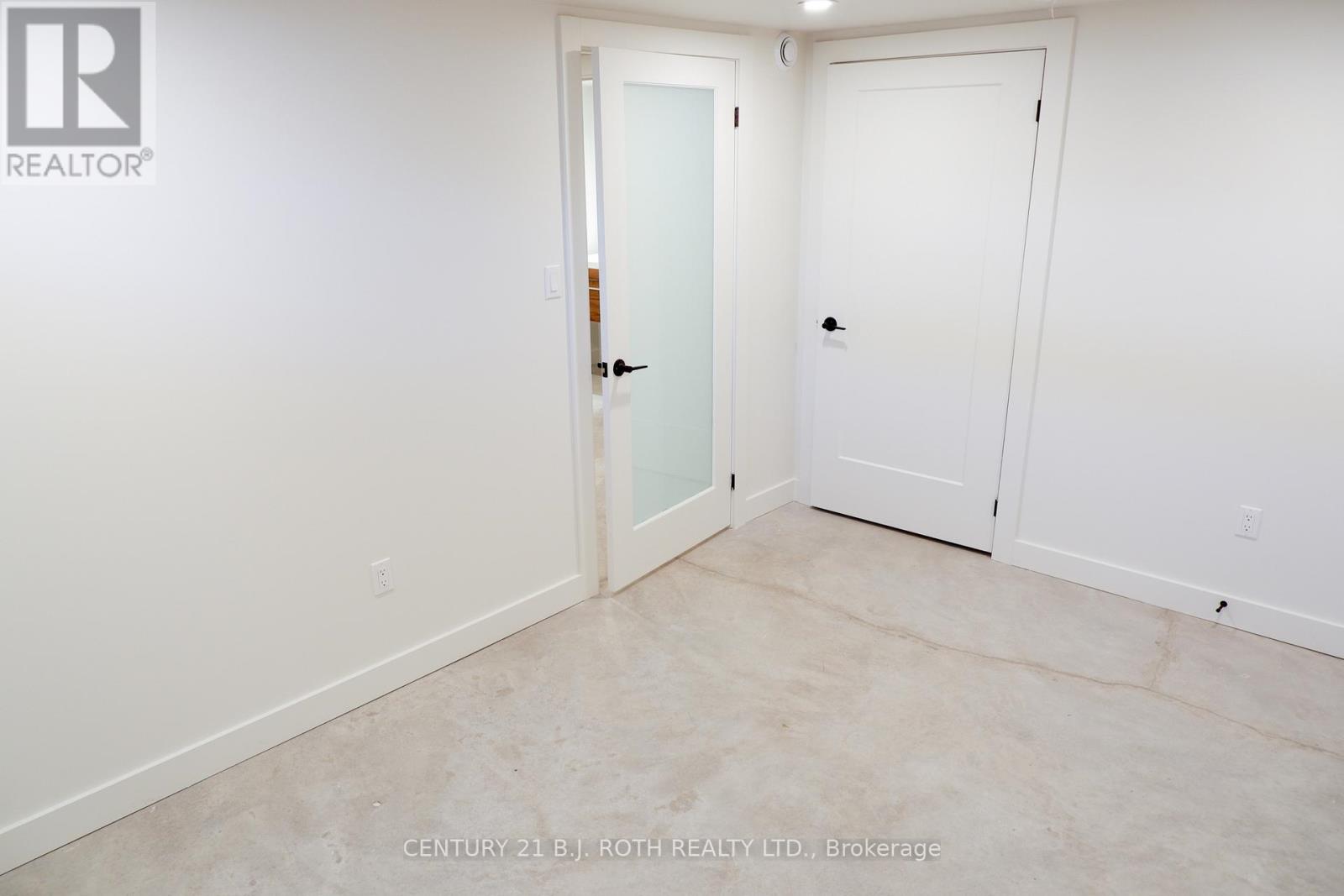 A white door is in a room with a white wall.