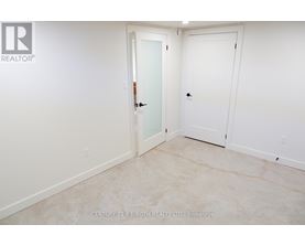 A white door is in a room with a white wall.