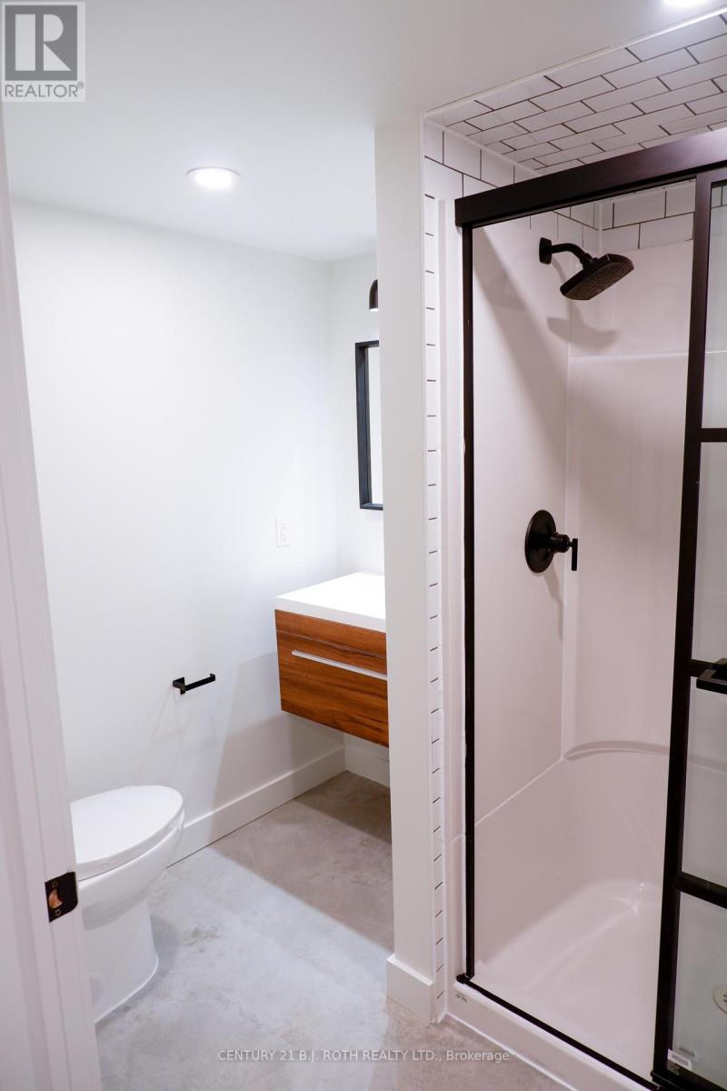A white bathroom with a toilet and a walk in shower.