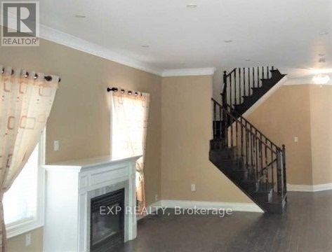 A living room with a staircase and a fireplace.