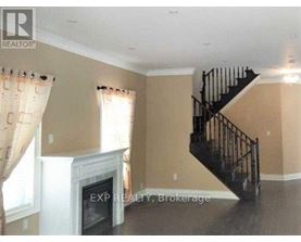 A living room with a staircase and a fireplace.