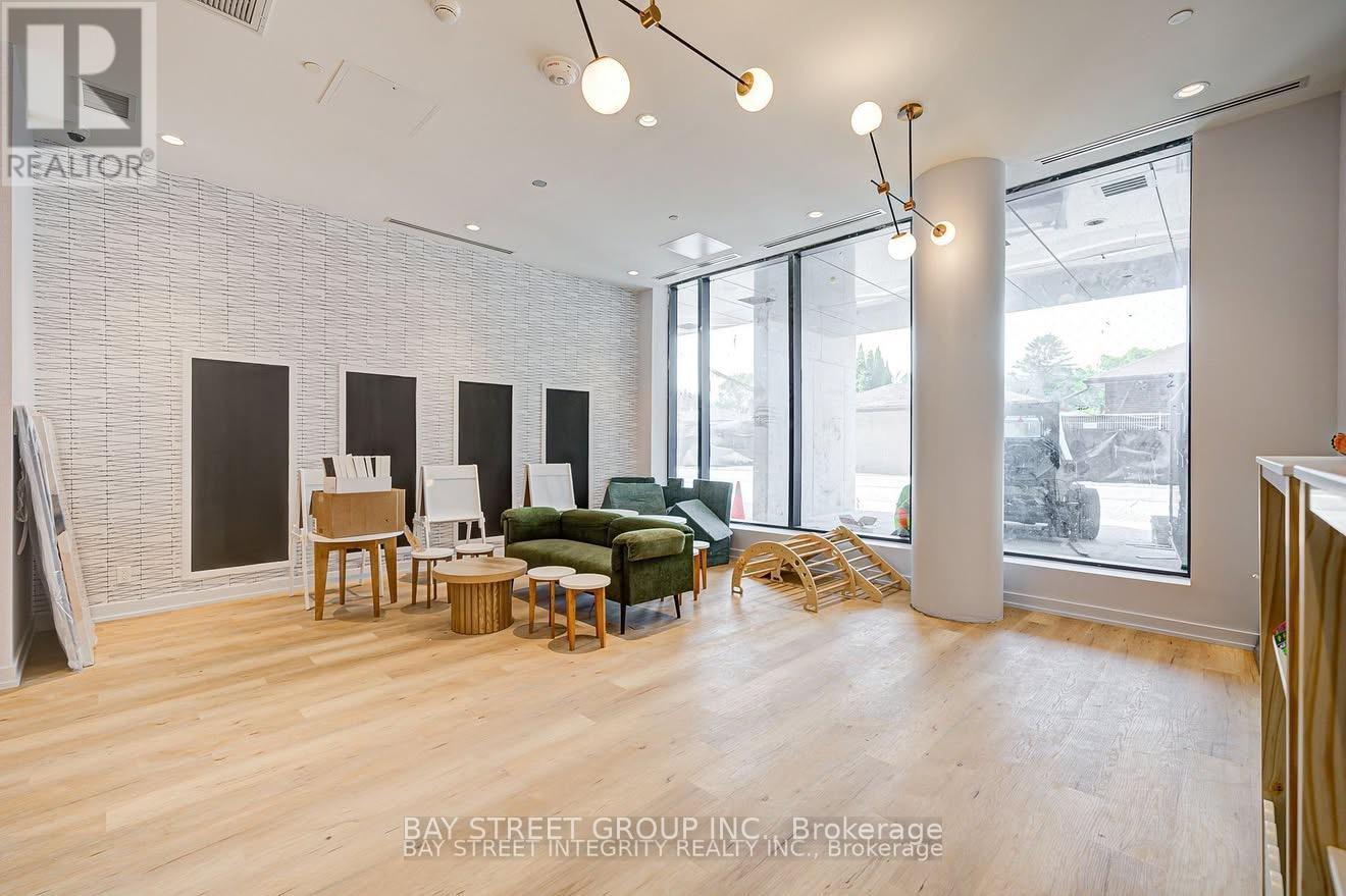 A spacious living room with a white brick wall and wooden flooring.