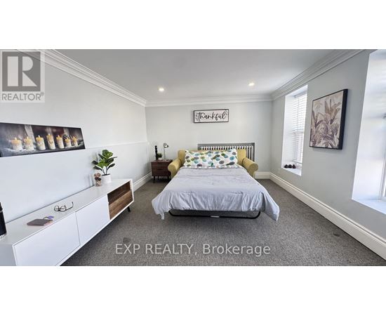 A bedroom with a bed, nightstand, and a wall-mounted shelf with a plant on it.