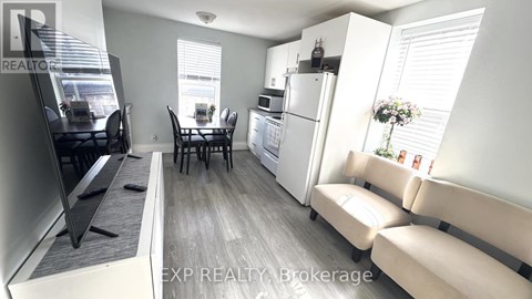 A well-lit kitchen with a dining table and chairs.