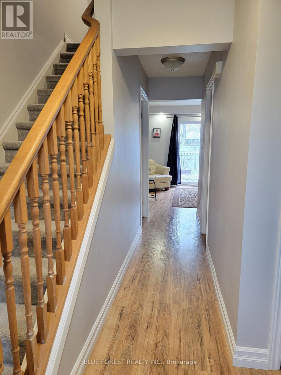 A hallway with a staircase on the left and a living room on the right.