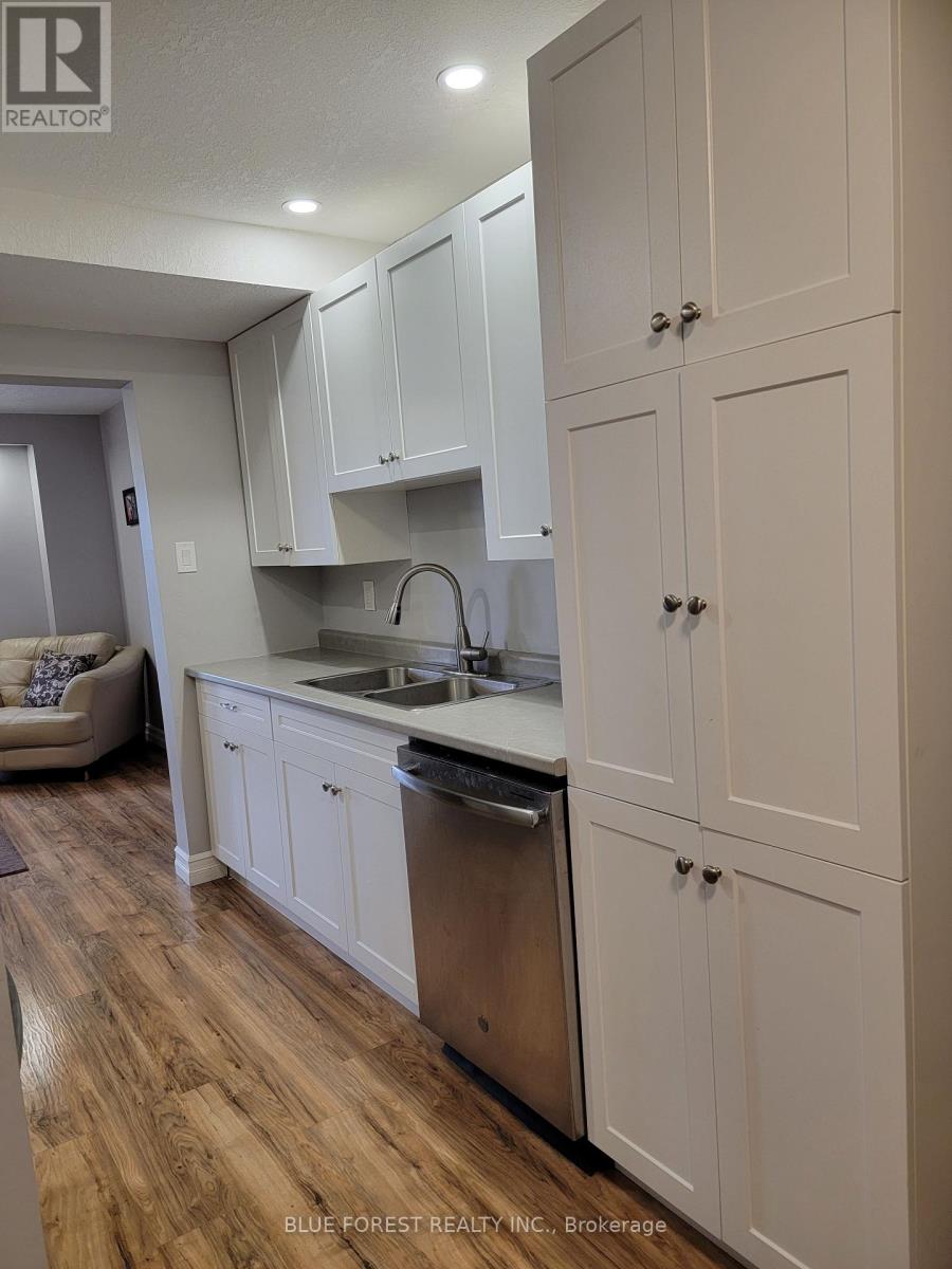 A kitchen with white cabinets and a wooden floor.