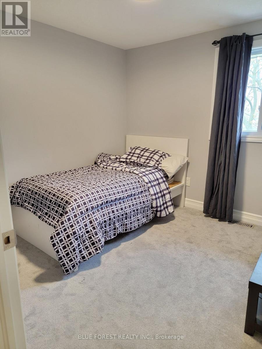 A bedroom with a bed covered in a black and white patterned bedspread.