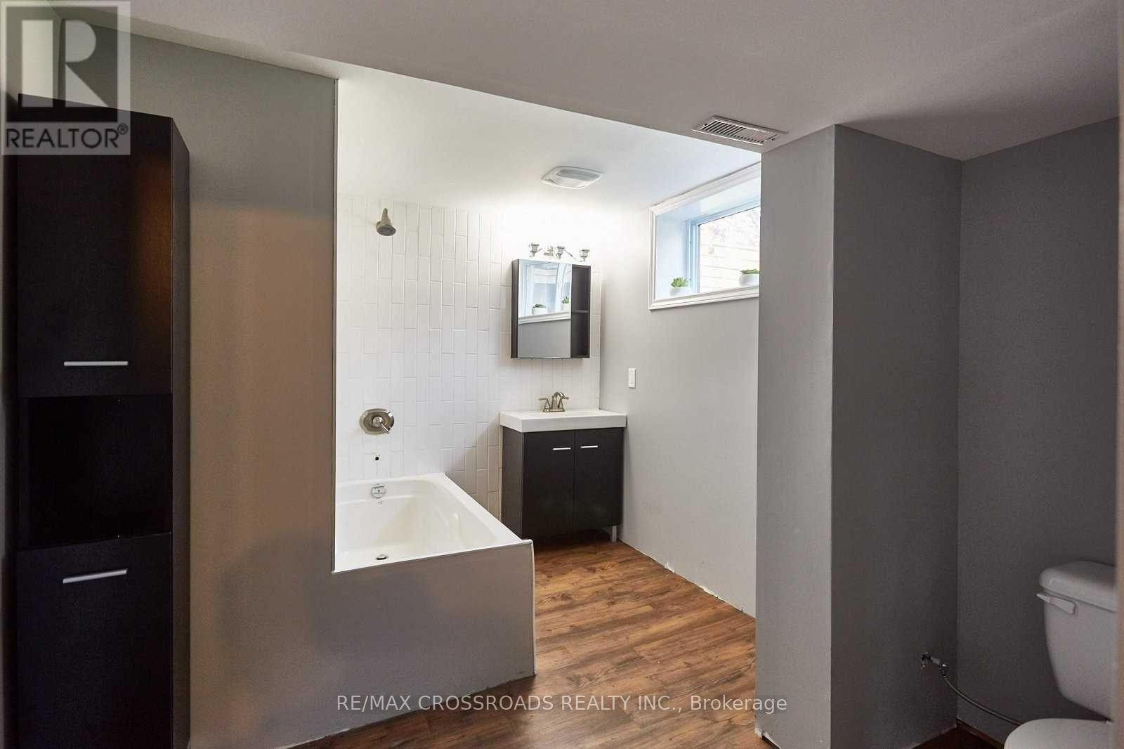 A bathroom with a tub, sink, and toilet.