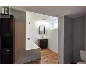A bathroom with a tub, sink, and toilet.