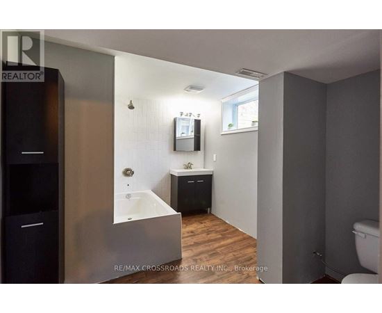 A bathroom with a tub, sink, and toilet.