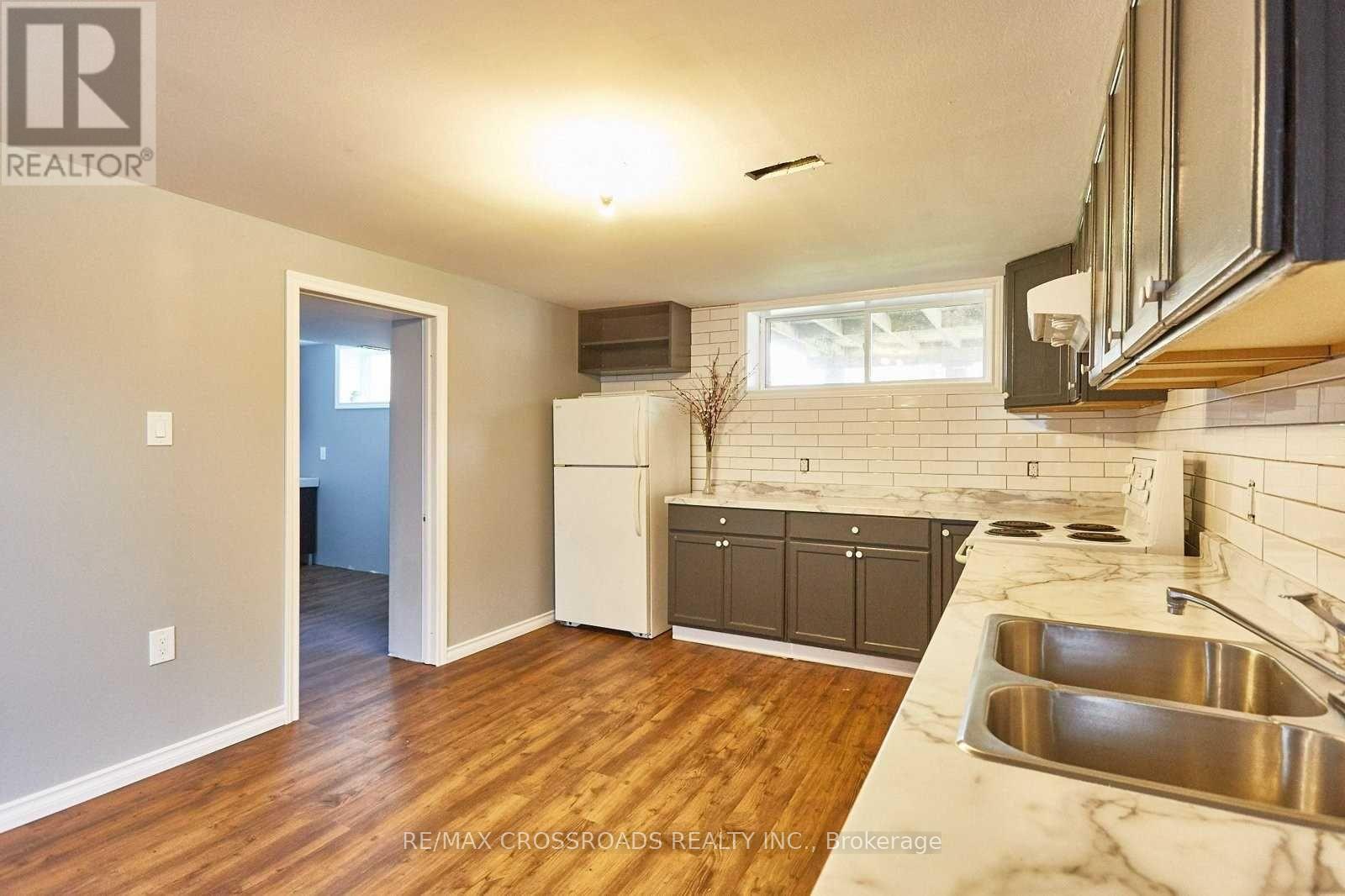 A kitchen with a sink and a refrigerator.