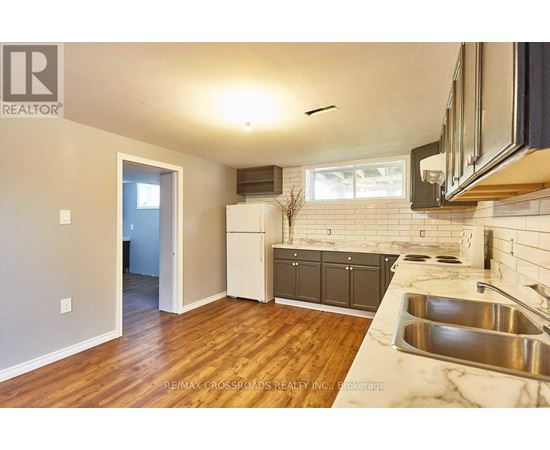 A kitchen with a sink and a refrigerator.