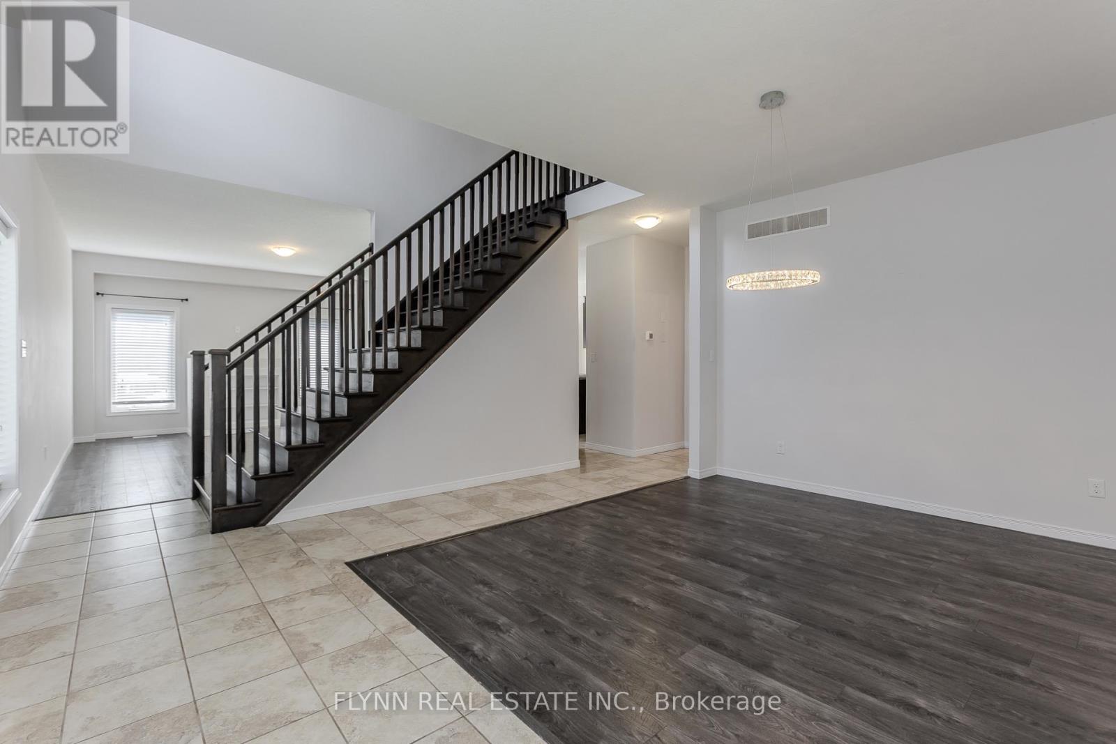 A spacious room with a staircase and a rug on the floor.