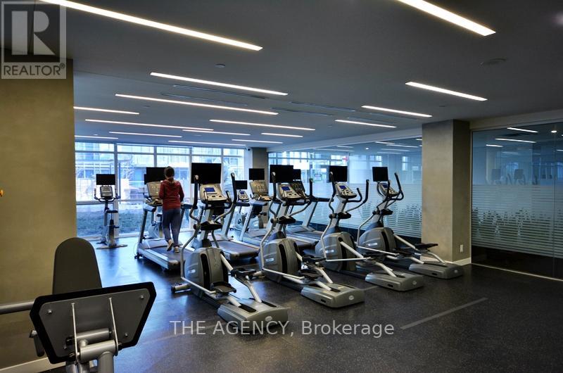 A gym with treadmills and a woman walking on a treadmill.