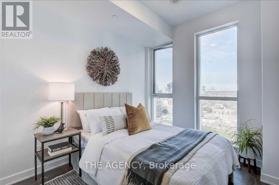 A bedroom with a bed, nightstand, and window.