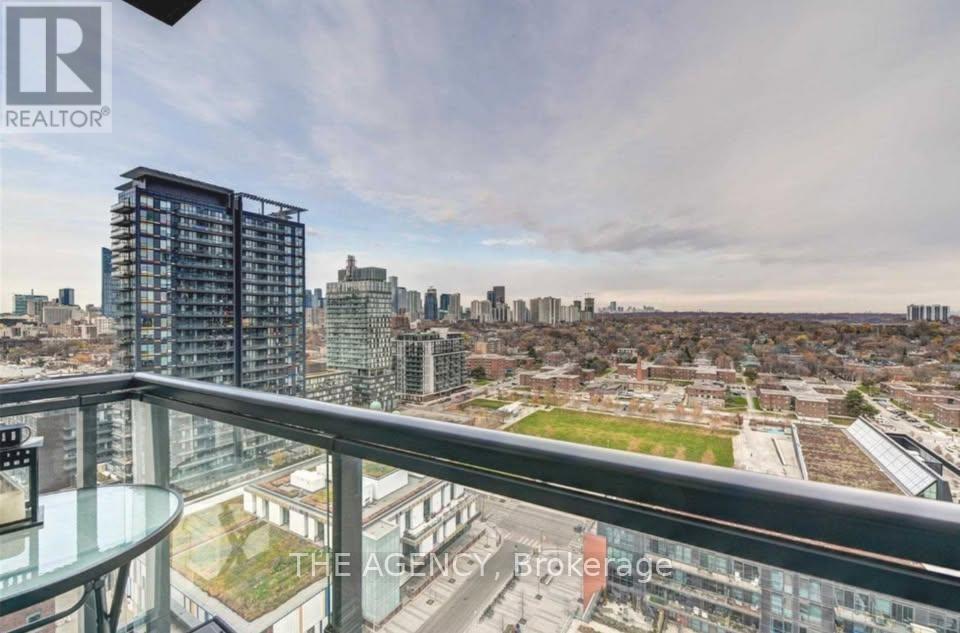 A balcony overlooks a cityscape with a mix of residential and commercial buildings.
