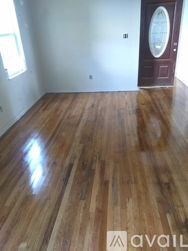 A room with wooden flooring and a door with a glass window.