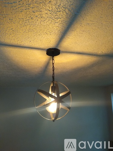A hanging light fixture with a star-shaped design is suspended from a chain.