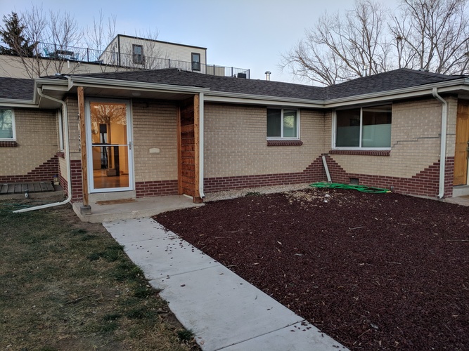 A house with a brown brick exterior and a white door.
