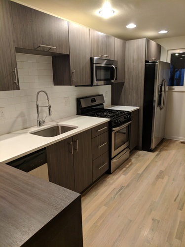 A kitchen with a sink, stove, and refrigerator.
