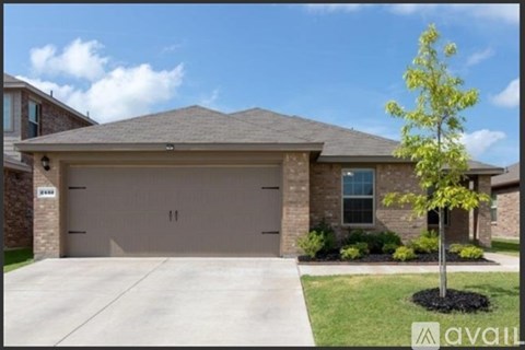 A house with a garage and a tree in front.