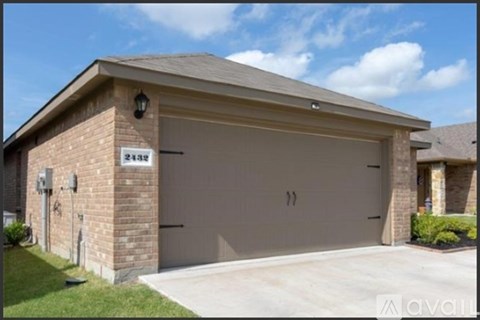 A two-car garage is attached to a brick house.
