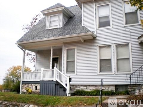 A house with a grey roof and white walls is for sale.